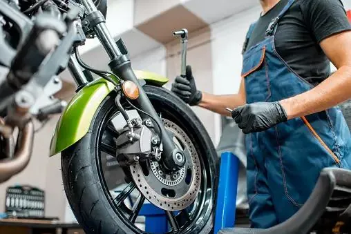 Technician servicing a motorcycle front wheel